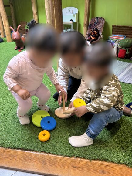 Toddlers playing together with stacking toys